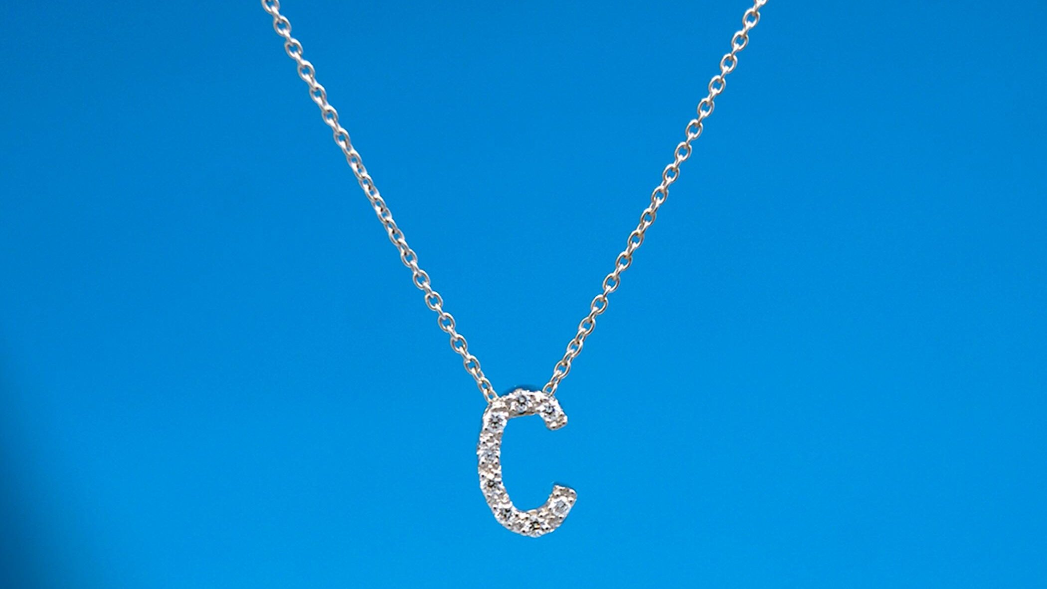Colgante de oro blanco en forma de inicial